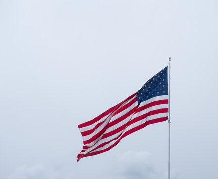 Unfurled American Flag against Gloomy Sky