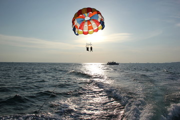 A man and a girl are flying on a parachute.