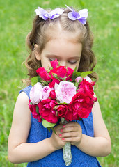 Child girl with bouquet of roses. Focus on the girl