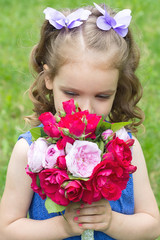 Child girl with bouquet of roses. Focus on the girl