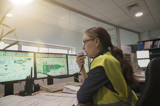 Woman In Industrial Control Room Using Radio To Give Instructions