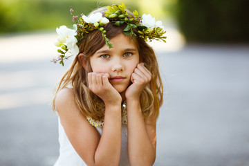 Beautiful girl with a wreath of fresh flowers