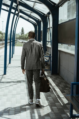 Stylish confident businessman walking on train station