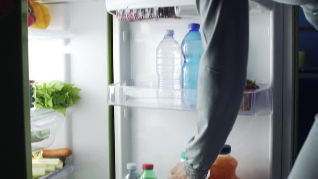 Woman taking a bottle of milk from the fridge