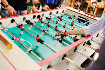 friends - guys and girls play table football.