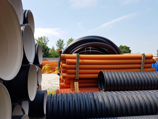 A warehouse of plastic pipes for various purposes, diameter and color under the open sky....