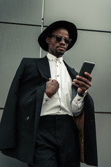 Handsome young african american businessman using smartphone