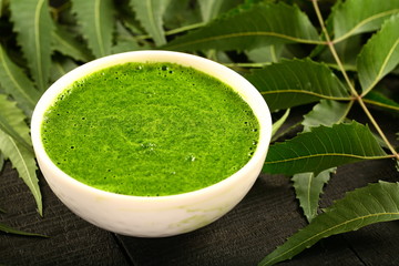 Herbal medicine- wild neem leaves cream in white bowl.
