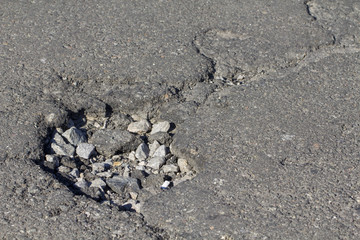 there are many potholes on the roadway close up