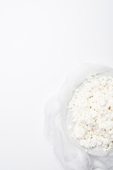 top view of homemade cottage cheese on cheesecloth on white surface