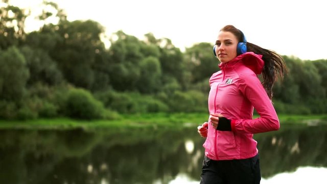 A morning jog in the Park near the pond in the Sunny rays of dawn, the girl is preparing to Mariano and lead a healthy lifestyle