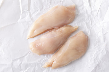 three chicken breasts on white paper.