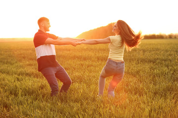 Happy young couple in green field on sunny spring day