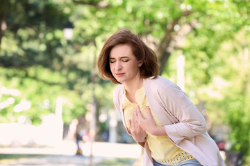 Mature woman having heart attack, outdoors