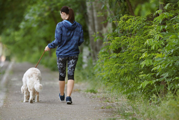 Young woman with her dog together in park. Pet care