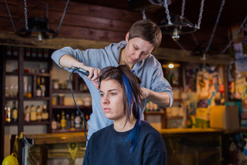 Professional hairdresser doing hairstyle for woman