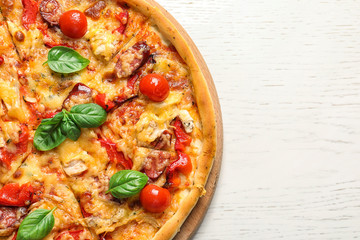 Delicious pizza with tomatoes and sausages on table, top view