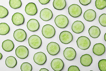Flat lay composition with slices of cucumber on white background