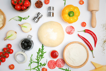 Dough and ingredients for pizza on white background, top view