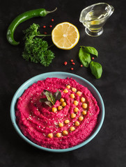 Hummus with beetroot on a black kitchen table.