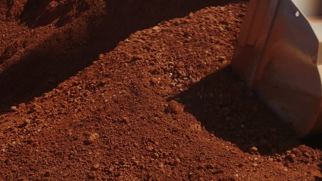 Wheel loader loading ore on dump trucks