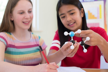 Two Female Pupils Using Molecular Model Kit In Science Lesson