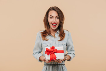 Fototapeta premium Portrait of an excited young girl holding present box