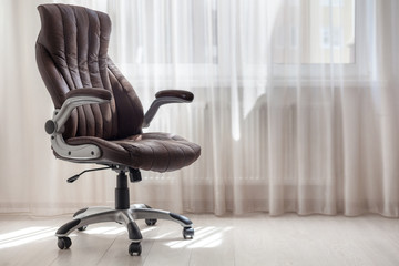 Comfort office chair in the room against window with tulle. Bright background