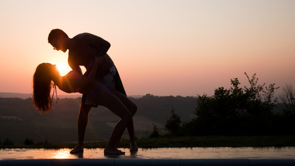 Romantic dance at sunset by couple