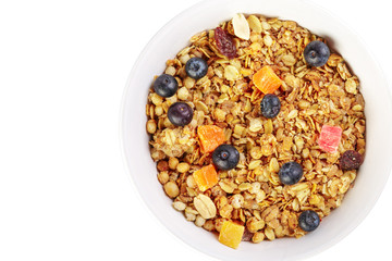 Bowl of homemade granola with fruit pieces isolated on white