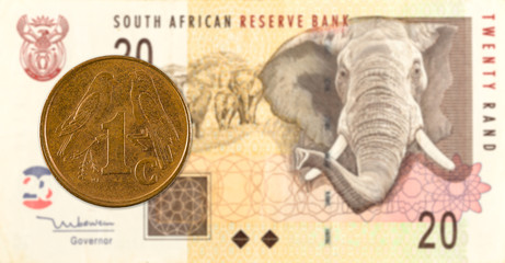 1 south african aforika coin against 20 south african rand banknote