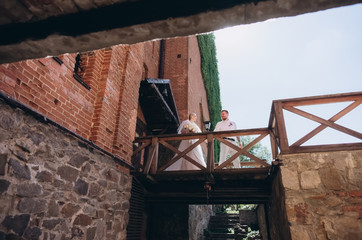 bottom view of beautiful bride and groom in front of entrance to ancient castle