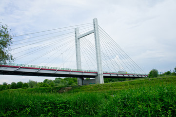 Big handsome cable-stayed bridge over the river against the sky