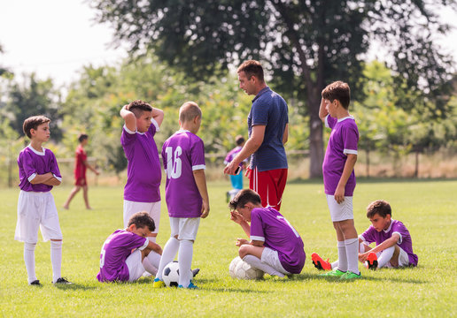 Coach is giving advice to  soccer players at football match