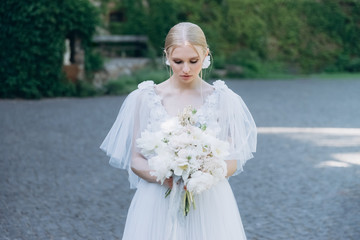 Fototapeta na wymiar sensual young bride in dress with bouquet