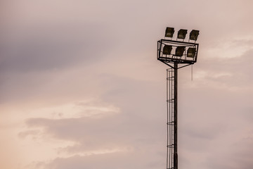 Bright sports stadium lights on a cloudy evening