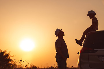 Father and son playing in the park at the sunset time.