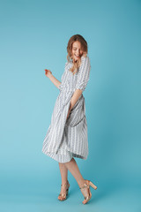 Full length image of Pleased woman in dress having fun
