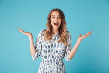 Surprised happy blonde woman in dress rejoices