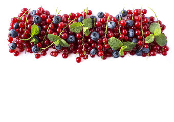 Ripe blueberries and red currants isolated on a white background. Mixed berries at border of image with copy space for text. Top view.