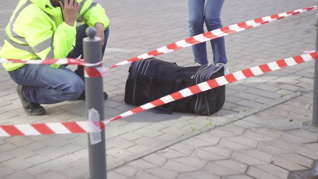 two police sappers next to a dangerous object, bag bomb attack on the street