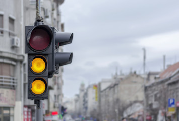 City urban semaphore with two yellow light with blury background
