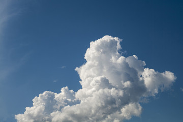Large white cloud in large format  in blue sky. White cloud lies in the focus of the camera, has...