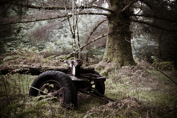 Old tractor abandoned in the middle of the forest corroded by rust and corrosion