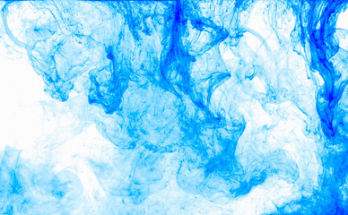 Abstract background. Blue ink in water, in motion. Color drop swirling. Colorful cloud of paint on white.