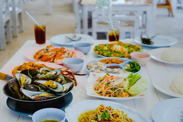 special Thai seafood (fish fried, Fried rice with crab, Crab's spawn salad, papaya salad, shrimp,Herb Roasted Mussels) on white table background. party concept.