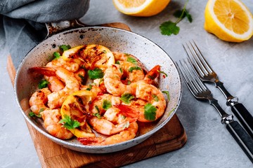 Spicy garlic chilli Shrimps on frying pan with lemon and cilantro