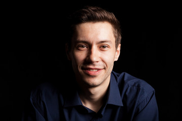 Portrait with fashion lighting of young man on black background