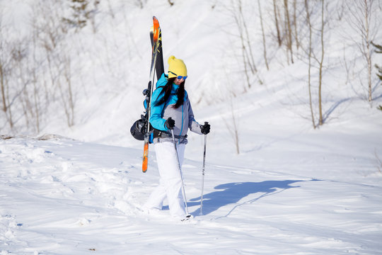 Photo of sporty woman with skis and sticks in winter