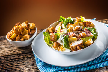 Delicious salad caesar with grilled chicken breast croutons eggs bacon parmesan cheese and  lettuce with dressing